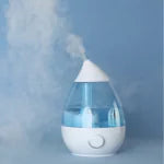 Modern air purifier releasing clean vapor against blue background