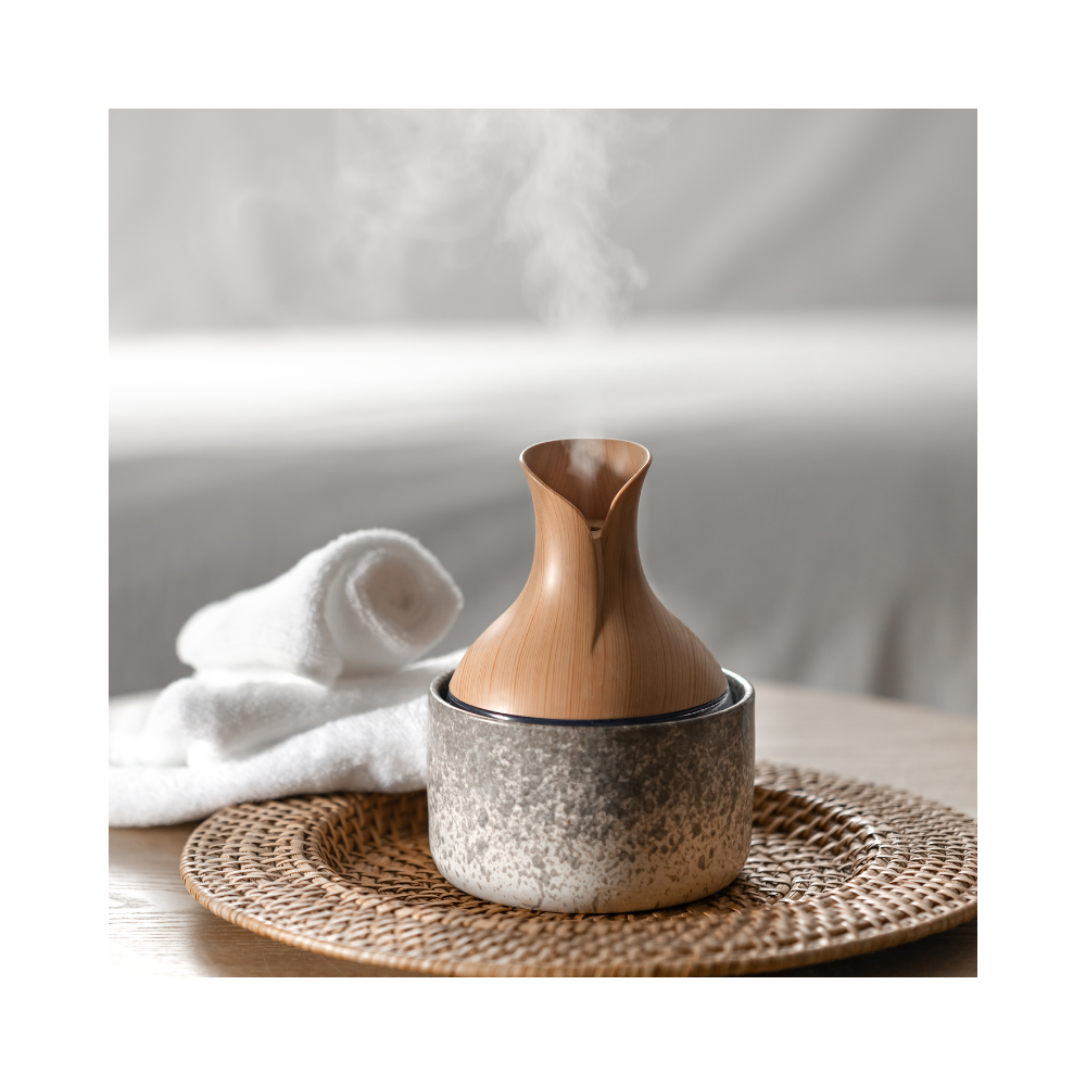 Elegant wooden diffuser releasing gentle steam surrounded by candles