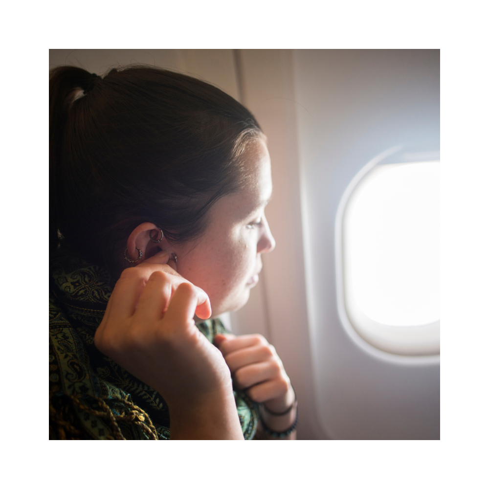 man wearing macks snoozer earplugs in plane
