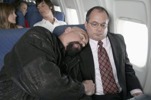 man asleep on other mans shoulder when travelling 