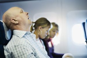 Man Snoring on Plane Travel Pillow