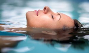 person in float tank wearing waterproof NOISE BLOCKING earplugs