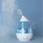 Modern air purifier releasing clean vapor against blue background